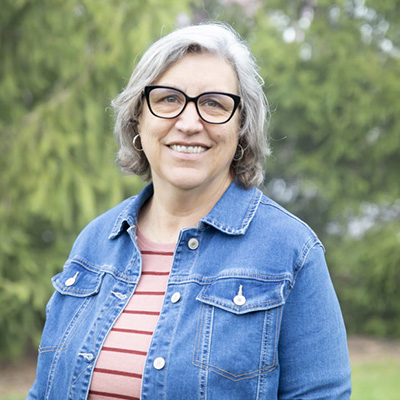 Smiling woman in denim jacket outdoors